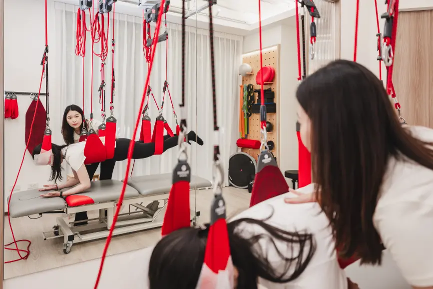 Cathy 教練帶領學員以 Redcord 進行俯臥腰椎穩定訓練,誘發核心肌群|逸力Elixir Movement Studio