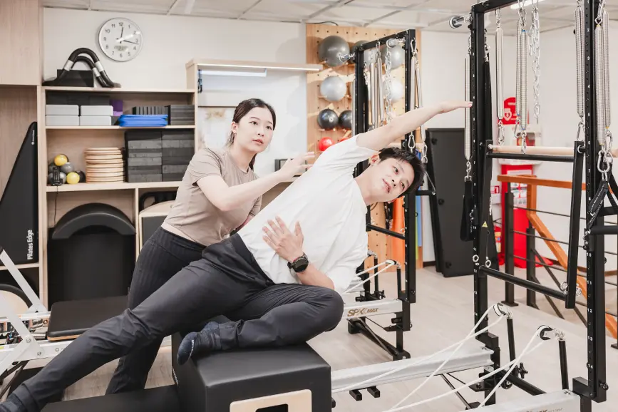 Cathy 教練帶領學員進行器械皮拉提斯側彎動作|逸力Elixir Movement Studio